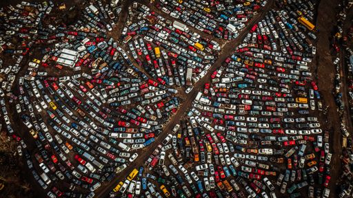An aerial view of a car park with vibrant colorful cars parked all around it