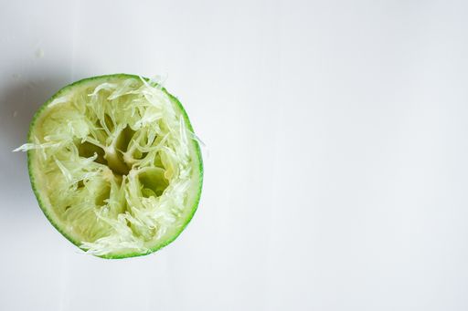 A high angle shot of a squeezed lime under the lights isolated on a grey background