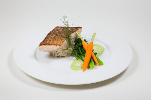 Line fish with carrots and broccoli on a white plate isolated on a white background