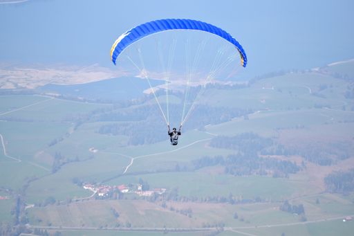 A closeup of a man jumping with a parachute