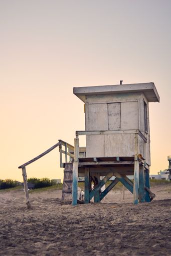 A wooden lifeguard observation tower on sandy beach