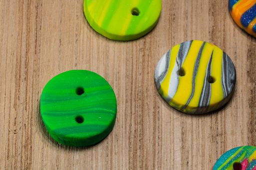A closeup shot of colorful buttons put on a wooden surface