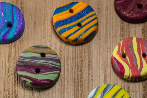 A closeup shot of colorful buttons put on a wooden surface