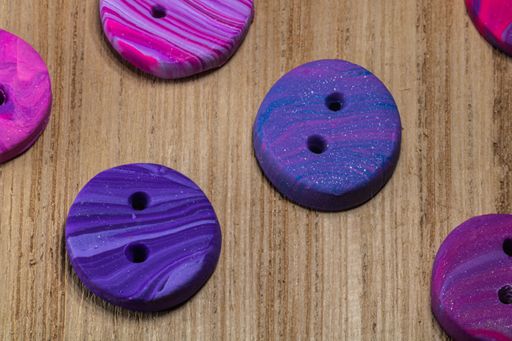 A closeup shot of colorful buttons put on a wooden surface