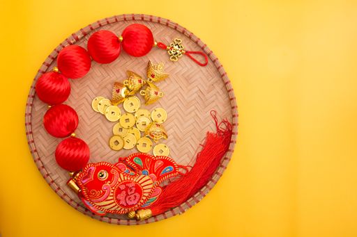 Lunar New Year decoration with lucky gold bar, lucky sacks, and red fish isolated on yellow . Tet Holiday.Translation of text appear in image: fortune