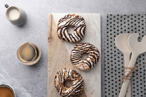 A top view of chocolate cream donuts on a messy kitchen table