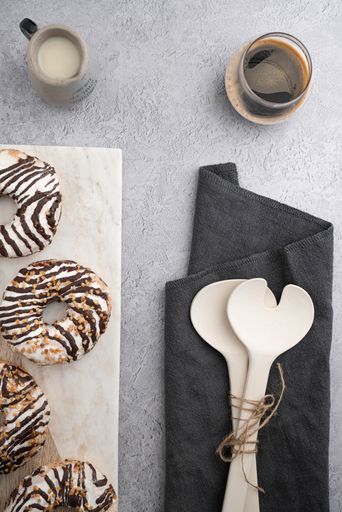 A vertical top view of chocolate cream donuts on a messy kitchen table