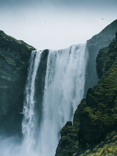 A vertical shot of the Skogafoss waterfall in Iceland on a gloomy day