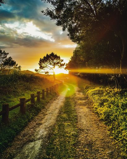 A mesmerizing scenery of a sunset over road in fields