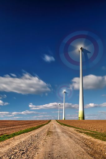 A vertical shot of the windmills in the countryside