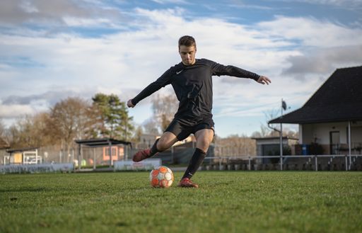 A view of the German soccer player kicking the ball in the field