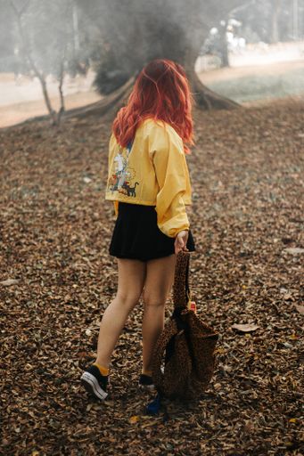 sad girl walking in the forest holding a backpack