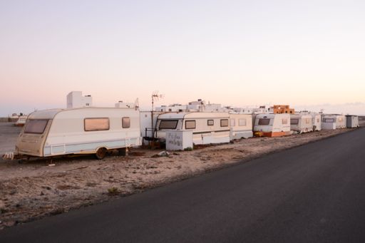 A beautiful asphalt road with camping vans on the side during sunset