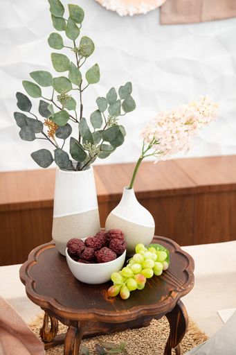 A closeup of flowers in pots near grape on a small table