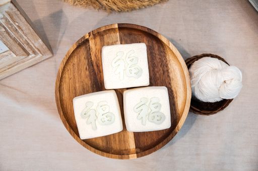 A top view of square soaps on a wooden plate