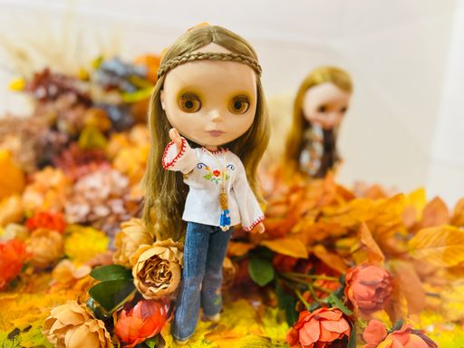 A closeup shot of a beautiful doll on the autumn leaves background