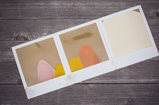 A high angle shot of polaroid photos with abstract images on a wooden surface