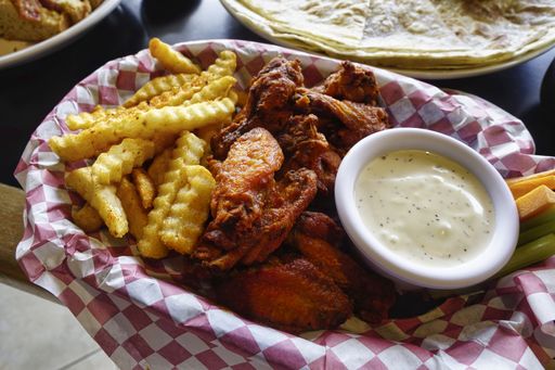 A high angle closeup shot of boneless chicken with french fries and dip sauce