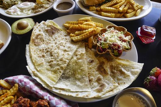 A high angle closeup shot of a plate of quesadillas on a black table
