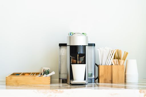 A juice extractor surrounded by kitchen utensils
