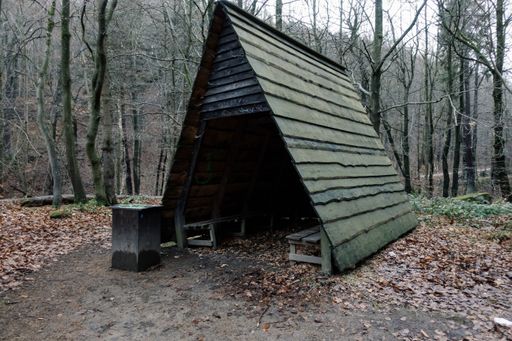 A closeup shot of a wooden tent shape with wooden chairs in it