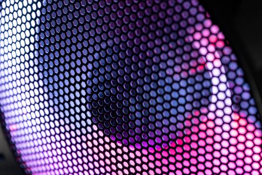 Detail of the case of a gaming pc with fan illuminated by rgb led and protection net