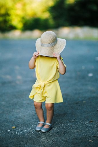 A closeup of a little girl in a yellow dress