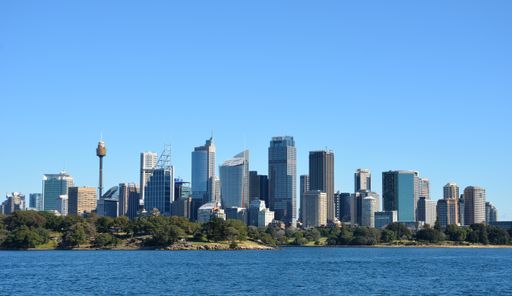 A beautiful view of the central Sydney skyline under a clear blue sky as seen from the harbor