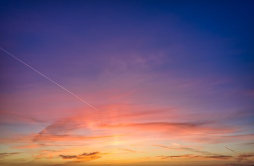 A beautiful sunset sky over Venice, California with many colors and a contrail