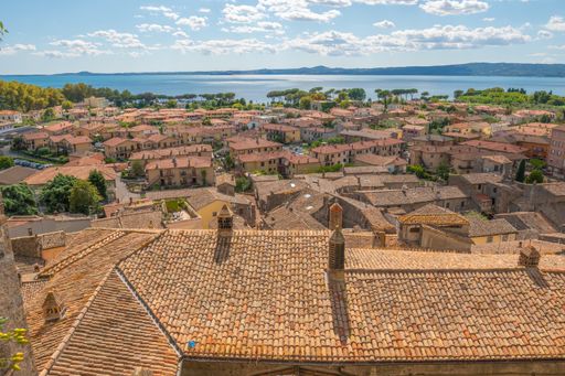 Old houses with tiled roofs of Onano under a blue cloudy sky on a sunny day
