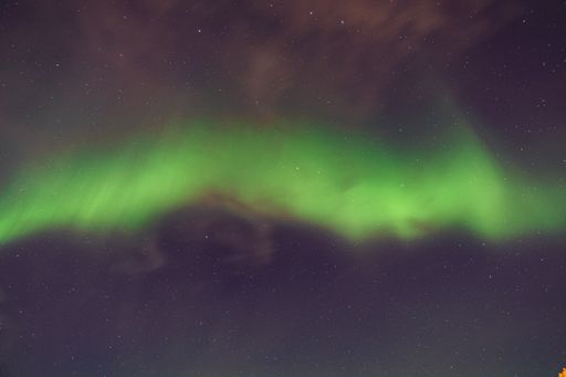 A beautiful wallpaper of the Nothern lights (Aurora Borealis) during the night in a small town