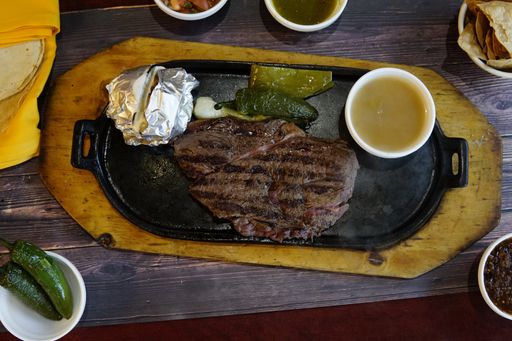 An overhead closeup shot of fine cuts of meat on a black plate