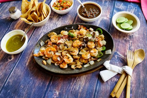 A high angle closeup shot of a dish with seafood on a black plate