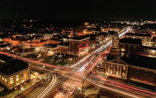 An aerial view of a beautiful city at nighttime with lights shining on the buildings and in the streets