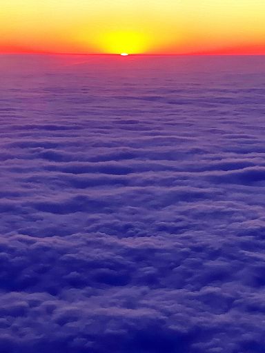 A vertical shot of sunset with blue clouds and yellow red sky