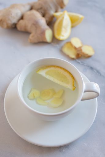 A vertical shot of a ginger tea with a slice of a lemon
