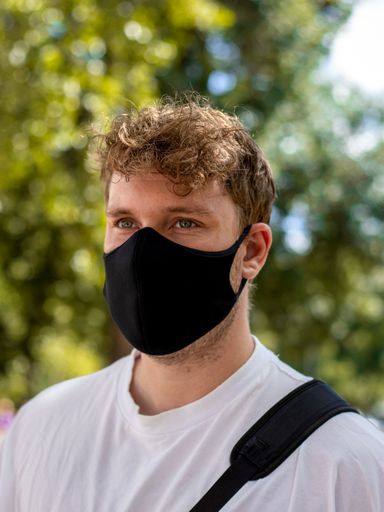 A young Caucasian male wearing a protective mask