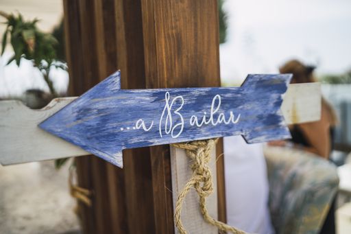 A horizontal shot of a blue signboard in the form of arrow pinned on a wooden column