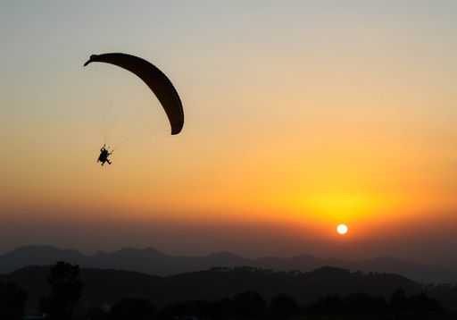 A beautiful shot of a human paragliding during sunset at Bir, Himachal Pradesh, India
