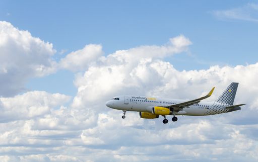 A photo of an airbus A320 plane of the Vueling airline, landing at  Barcelona Airport