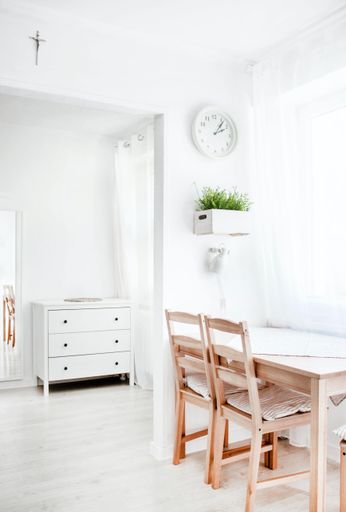 A vertical shot of a white interior with wooden elements