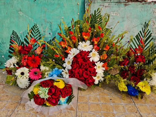 A view of a few bouquets on the ground near an old wall