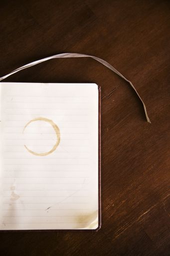 An overhead vertical shot of a blank notebook on a wooden surface