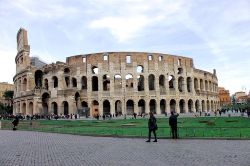 A panoramic view of the side of the Colosseum, Coliseum against a cloudy blue sky. Rome, Italy