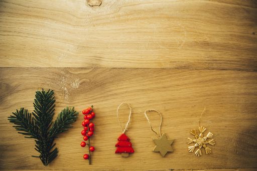 An overhead shot of Christmas ornaments on a wooden table
