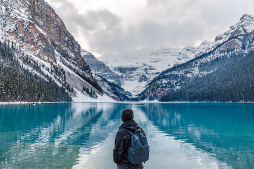A back view of a hiker enjoying the view on Lake Louise in Banff, Canada
