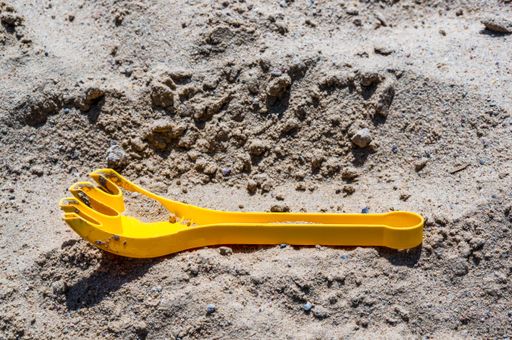 A closeup shot of a yellow toy for playing in the sand on the beach
