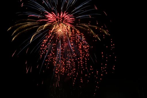Bright festive fireworks (rays of light) on a dark background of the night sky.