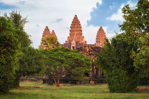 A beautiful shot of an Angkor Wat Buddhist temple with a green garden