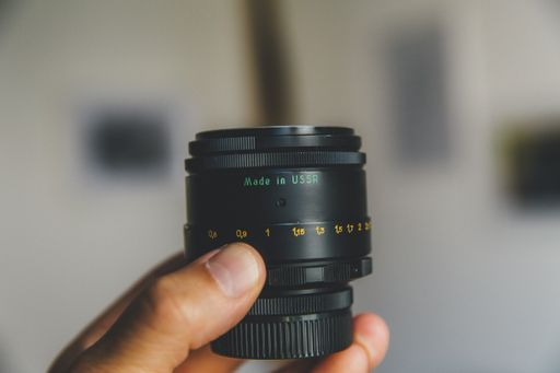 A close shot of a person holding a camera lens with a blurred background